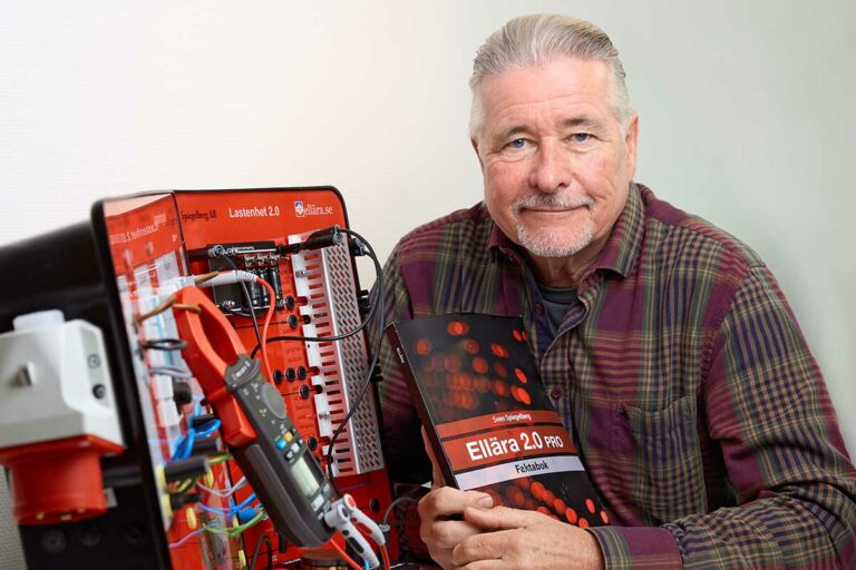 Läromedelsförfattaren Sven Spiegelberg som sitter vid ett bord där också hans labbutrustning står, den används som en modell av ett lågspänningsnät.