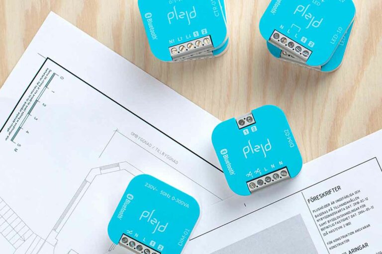 Turkosa Plejdpuckar ligger på ritningar på en plywoodskiva